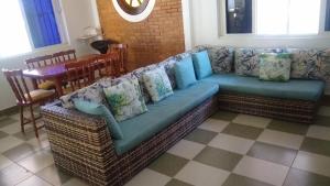 a couch with pillows on it in a living room at Casa para finais de semana temporada in Caraguatatuba