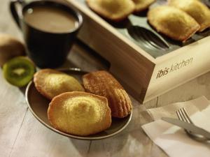 a plate of donuts on a table with a cup of coffee at ibis Bordeaux Centre - Gare Saint-Jean in Bordeaux