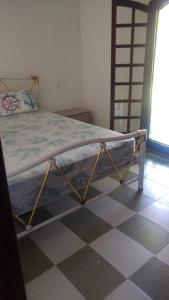 a bed in a bedroom with a checkered floor at Casa para finais de semana temporada in Caraguatatuba