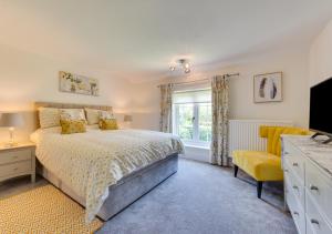 a bedroom with a bed and a tv and a window at The Firs in Brundall