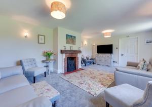 a living room with a fireplace and a tv at The Firs in Brundall