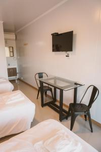 Pokój ze stołem, krzesłem i telewizorem w obiekcie HOTEL CONCHILLAS w mieście Conchillas