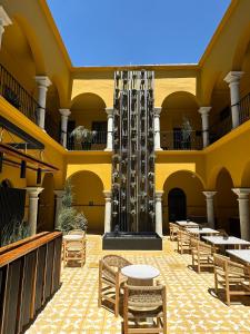 einen Innenhof mit Tischen und Stühlen in einem Gebäude in der Unterkunft Hotel Casona Oaxaca in Oaxaca de Juárez