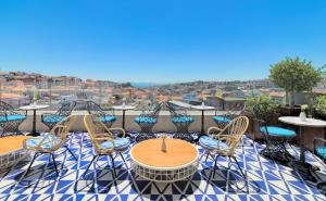 un patio con mesas y sillas en la azotea en H10 Duque de Loule en Lisboa