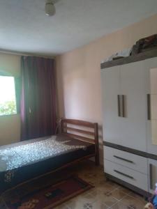 - une petite chambre avec un lit et une commode dans l'établissement Casa IKEDA, à Suzano