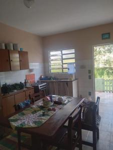 une cuisine avec une grande table et des chaises en bois dans l'établissement Casa IKEDA, à Suzano