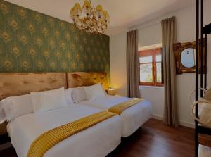 - une chambre avec un grand lit blanc et un lustre dans l'établissement Libelle Andalusian Hideaway C, à Grenade