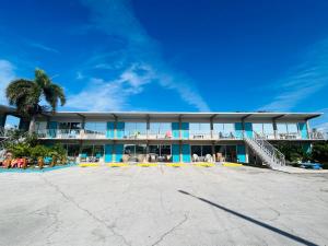 a building on the beach with a palm tree at Big Pine Key Motel in Big Pine Key