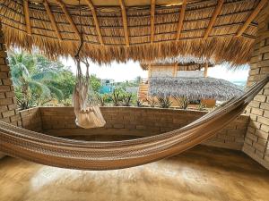 a hammock in a resort with a bed in the background at Villa Macarena Apartamentos Boutique - Adults Only in Puerto Escondido