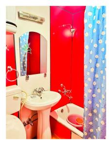 een badkamer met rode muren, een wastafel en een toilet bij Gulbahaar Group Of HouseBoats in Srinagar