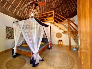 a bedroom with a bed with a canopy in a room at Kameleon Blue in Kizimkazi