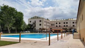 a hotel with a swimming pool in front of a building at Hotel Castilla Torrijos in Torrijos