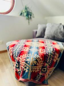 a bed with a colorful blanket on it in a room at Kåseberga Hideout in Kåseberga