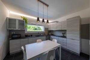 a kitchen with white cabinets and a white table at Casa Ardesia 