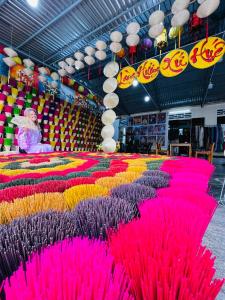a large display of pink and purple feathers in a store at Full House Homestay in Hue