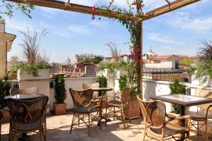 a patio with chairs and tables on a balcony at TB Place Roma in Rome