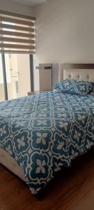 a bedroom with a bed with a blue and white comforter at Casa 3 dormitorios J2 in Cuenca