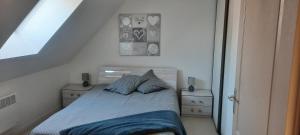 een slaapkamer met een bed met blauwe lakens en kussens bij La Maison LOLA in Arrest