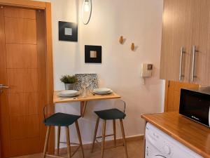 una pequeña cocina con una mesa pequeña y 2 taburetes en Loft Plaza Bailen, en Málaga