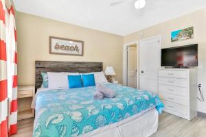 a bedroom with a large bed with a television at Pelican Beach Studio 7 in Clearwater Beach