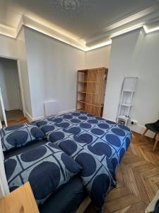 パリにあるSweet-cosy apartment Near république placeのベッドルーム1室(大型ベッド1台、青い掛け布団付)