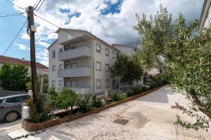 a large white building in front of a parking lot at Villa Eight by Villa Kuzmanić in Trogir