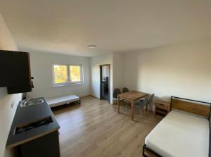 a room with a bed and a desk and a table at Zimmer mit Bad und Küche in Rötgesbüttel