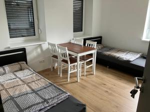 - une chambre avec une table, des chaises et 2 lits dans l'établissement Zimmer mit Bad und Küche, 