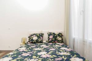 een slaapkamer met een bed met een bloemendeken en kussens bij Duplex en plein centre historique Aix en provence in Aix-en-Provence