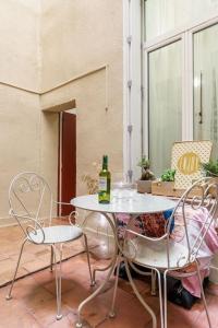 een tafel en twee stoelen en een fles wijn bij Duplex en plein centre historique Aix en provence in Aix-en-Provence