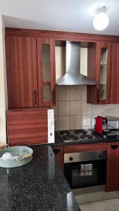 a kitchen with wooden cabinets and a stove top oven at Zenko Suave- 12 Madison West in Johannesburg