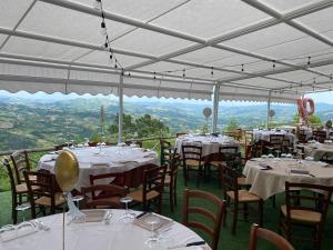 a restaurant with white tables and chairs with a view at Lo Scoiattolo Country House in Montorio al Vomano