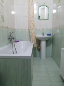 a bathroom with a bath tub and a sink at Eleon in Umanʼ