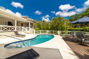 a villa with a swimming pool and a patio at Hullabaloo in Saint James