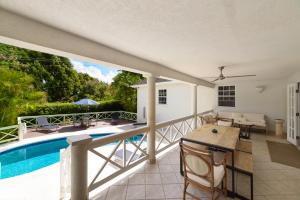 a patio with a pool and a table and chairs at Hullabaloo in Saint James