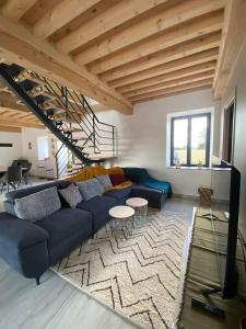 sala de estar con sofá azul y alfombra en La Ferme du Maillot, en Champeau