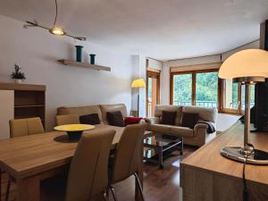 cocina y sala de estar con mesa y sofá en Allotjaments Bruc en Camprodon
