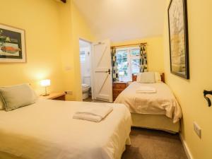 2 łóżka w pokoju z żółtymi ścianami w obiekcie The Stable w mieście Lyme Regis
