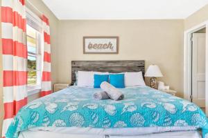 a bedroom with a bed with a blue and white comforter at Pelican Beach Studio #8 in Clearwater Beach