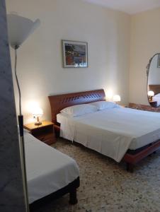 a bedroom with two beds and two lamps and a mirror at Lucia's apartaments in Bari Palese