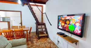 sala de estar con TV de pantalla plana y mesa en Recanto Flor de Jasmim, en Ilhabela