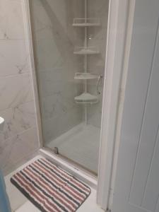 um chuveiro com um tapete no chão na casa de banho em W3 Guest House em Londres