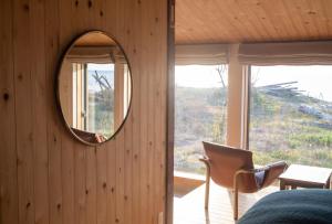 einen Spiegel an der Wand eines Zimmers mit einem Stuhl in der Unterkunft sailor's house - Vacation STAY 77417v in Wajima