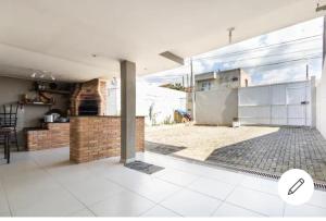 a living room with a large window and a patio at Quarto em Casa da Família Anton in São José dos Pinhais