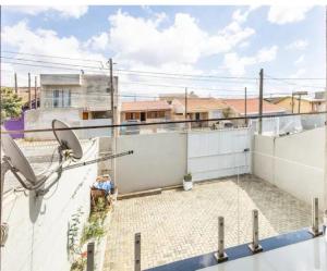 a person sitting on top of a balcony at Quarto em Casa da Família Anton in São José dos Pinhais