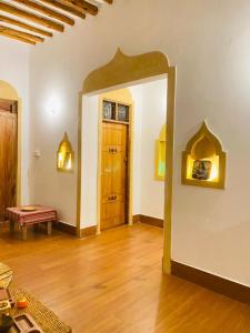 una stanza vuota con una porta e un pavimento in legno di Nakupenda House a Jambiani