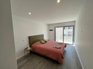 a bedroom with a large bed with a red blanket at Luxury flat with ocean view Nazaré Sitio in Nazaré
