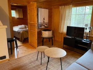 a living room with a room with a bed and a tv at Ylläs Seita cottage in Kittilä