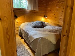 a bedroom with a bed in a wooden cabin at Ylläs Seita cottage in Kittilä