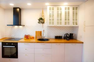 a kitchen with white cabinets and a sink at Bochenka Apartments II in Krakow